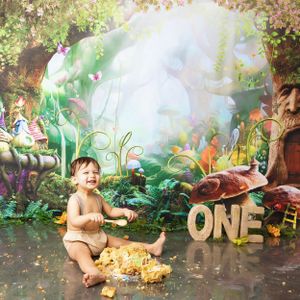 Magical forest-themed first birthday setup with word 'ONE' and ethereal lighting effects in a whimsical garden scene.