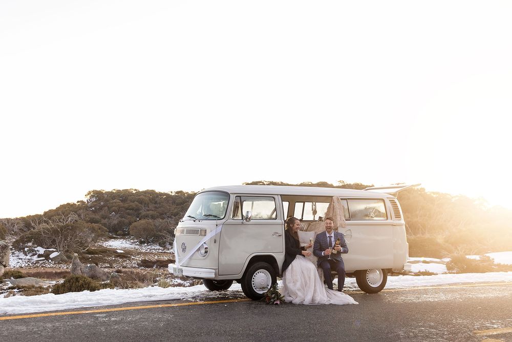Bride and Groom sitting in a VW Kombi in the snow at Mount Buffalo at Sunset.