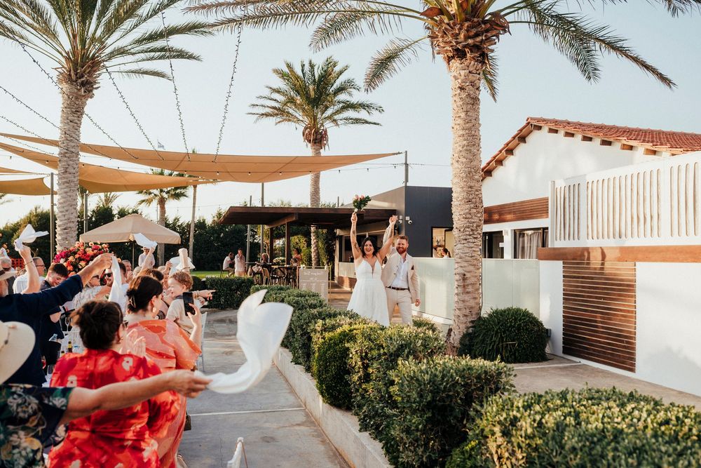 A luxury beachfront resort with palm trees and white cabanas lining a pristine sandy beach at sunset.
