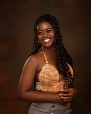 Creative studio portrait of a woman posing energetically with one arm raised against a dark background.
