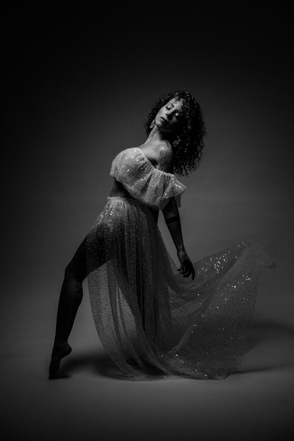 Dramatic black and white portrait of a dancer in a flowing sparkly dress striking an elegant pose Tänzer Portrait Shooting Frankfurt