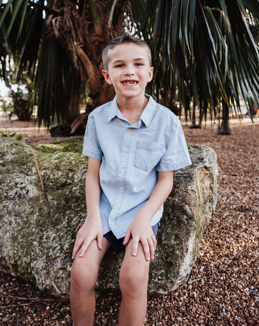 Outdoor Headshot Session Gisela Kopsick Arboretum in Saint Petersburg, FL; young boy posing on a rock