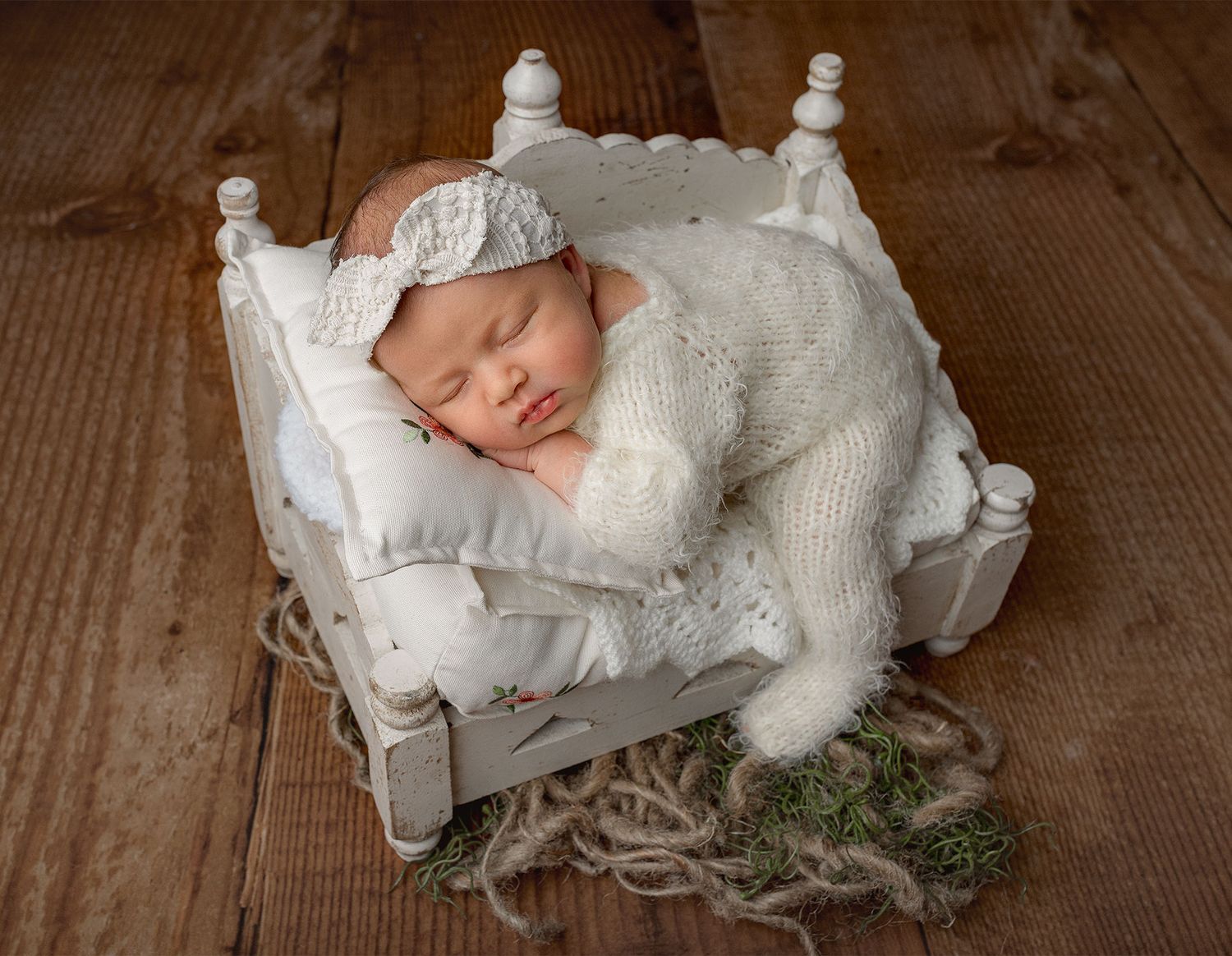 Newborn baby girl posed in a tushy up position on a styled studio bed featuring soft textures, gentle lighting and timeless details.