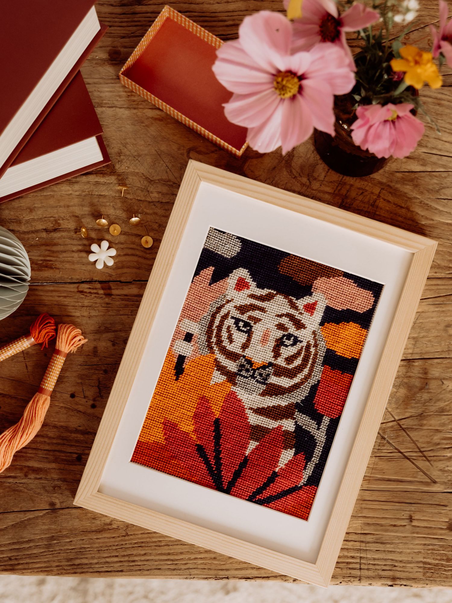 Elegant table setting with floral patterns, glassware and fresh flowers in warm lighting.