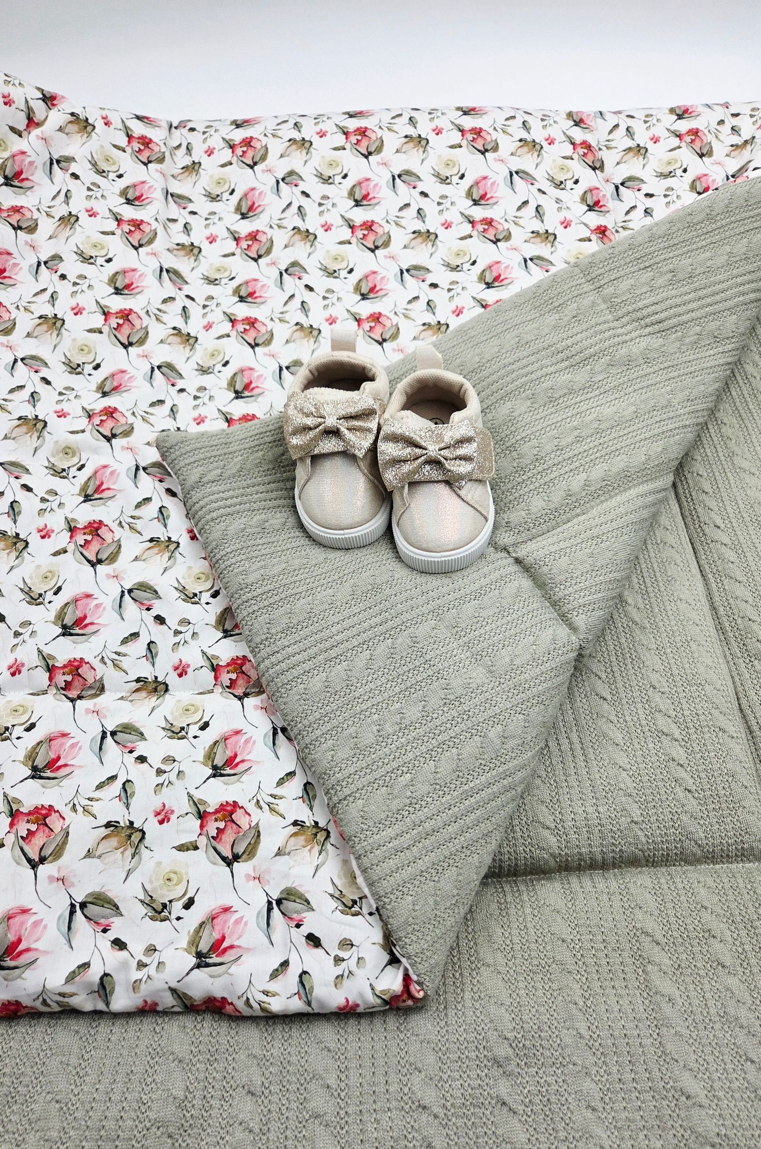 Gray knit blanket with floral print fabric and matching baby shoes.