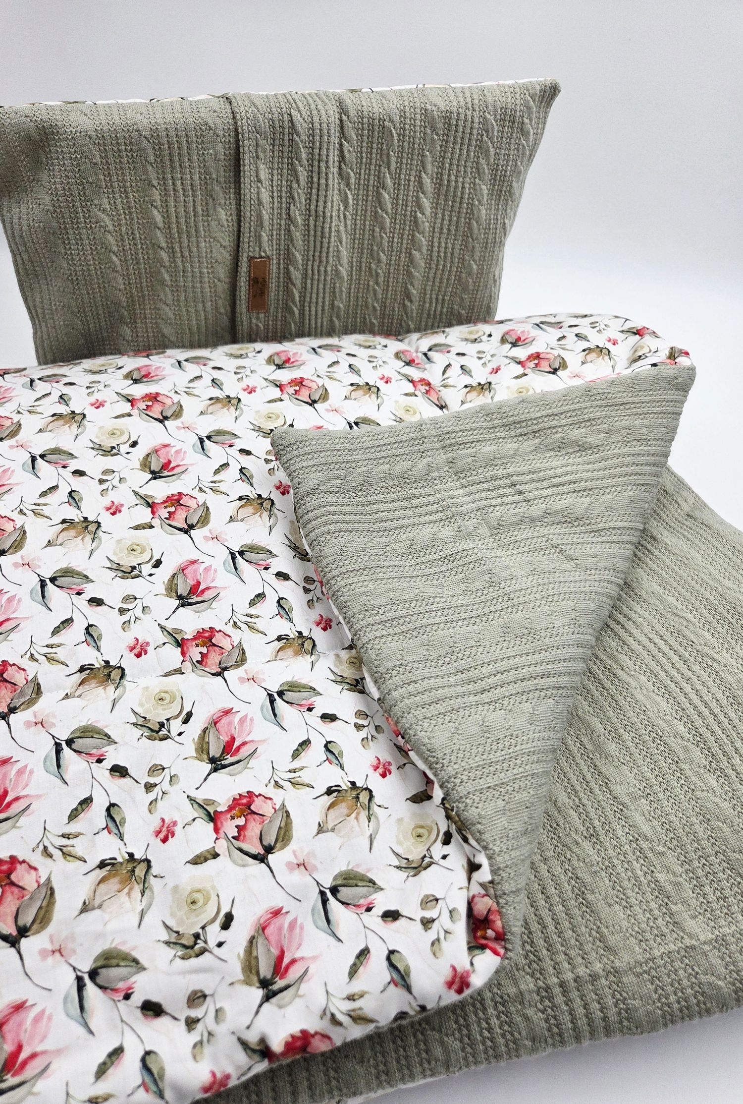 Handmade baby blanket featuring sage green cable knit and floral print fabric with pink roses.