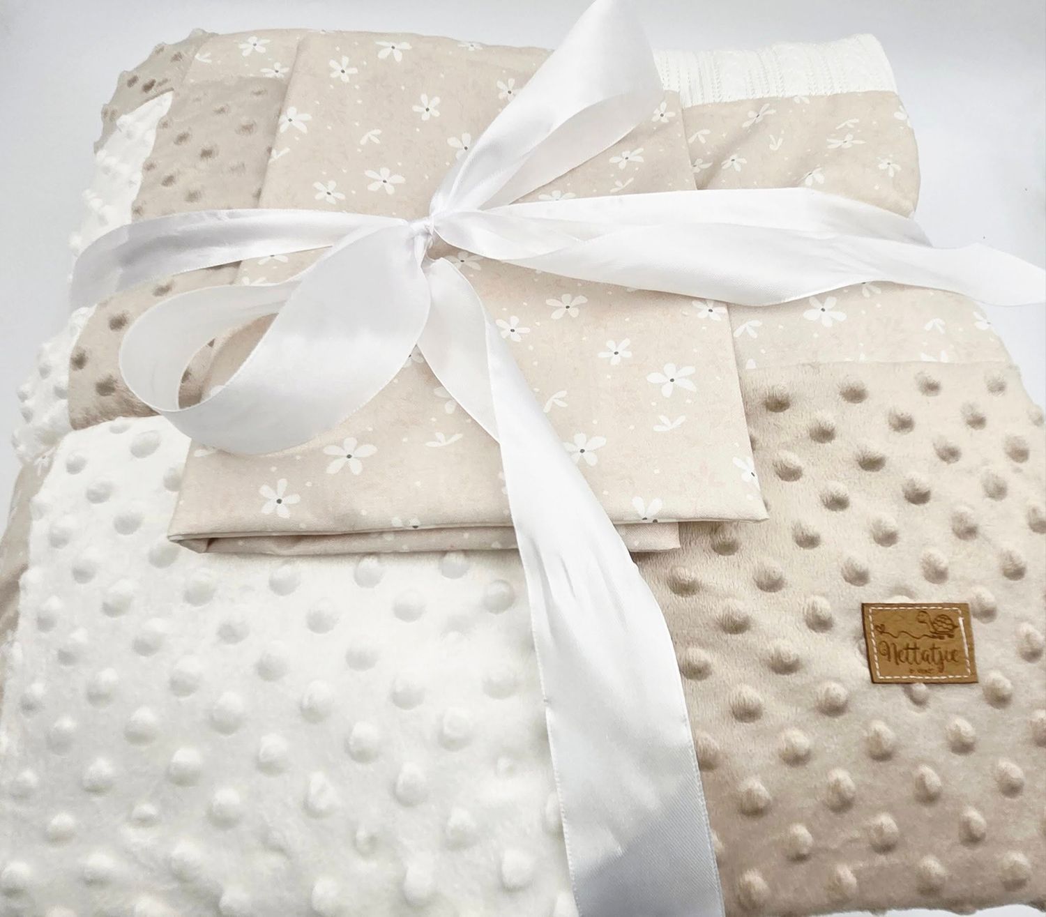 Close-up of plush minky baby blanket with white satin ribbon detail.