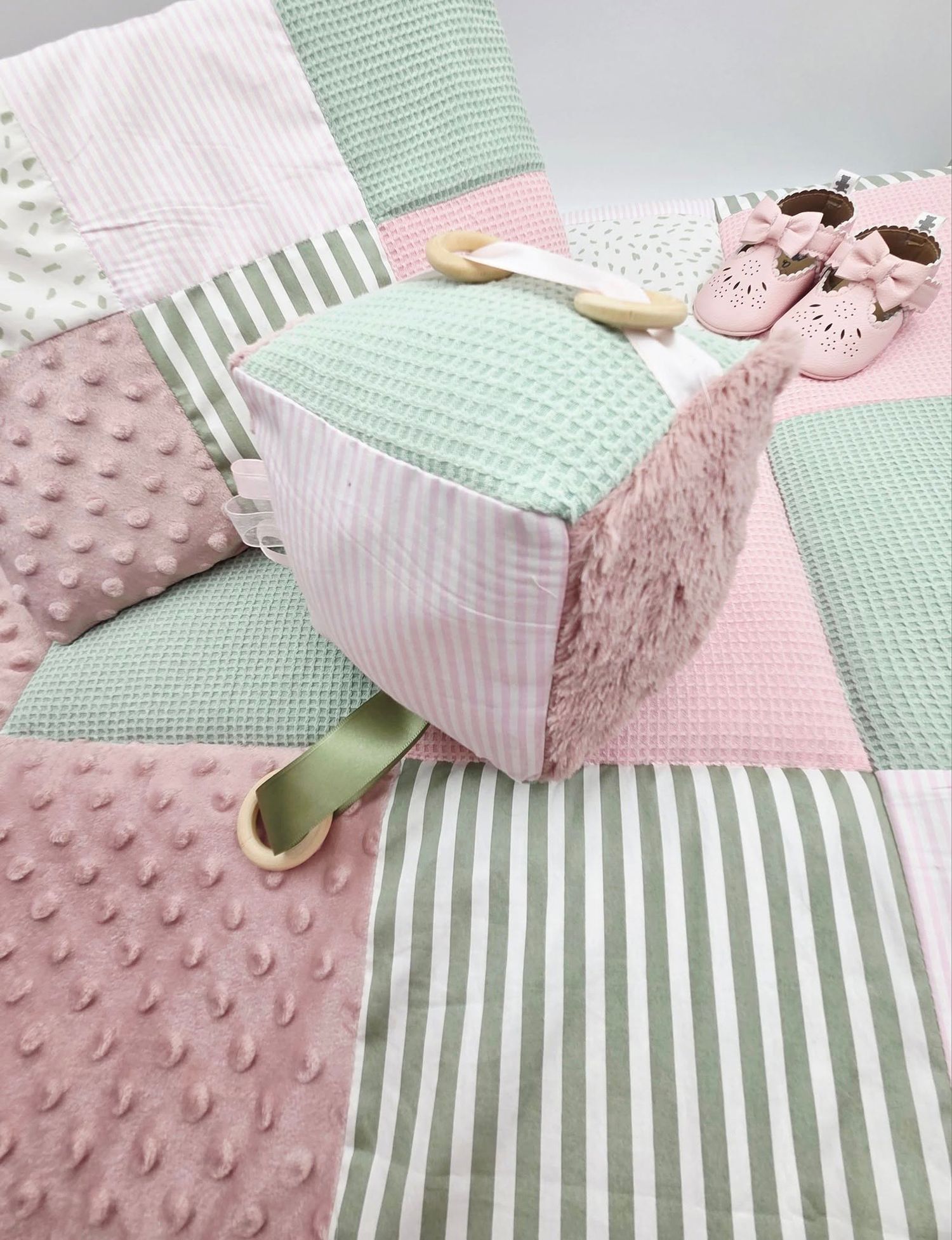 Patchwork baby blanket featuring mint green stripes and pink minky dot textures.