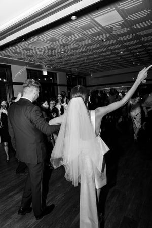 Black and white photo of a couple's first dance at their luxury Chicago wedding reception with guests looking on.