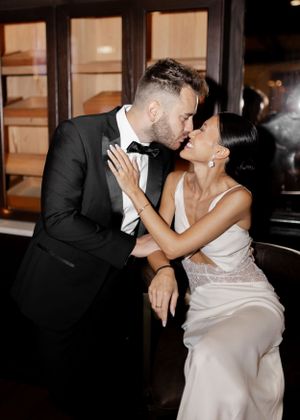 Romantic couple in formal wedding attire sharing an intimate moment during their reception.
