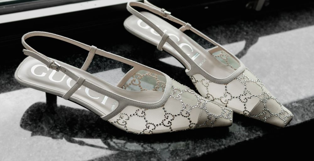 Designer slingback shoes with monogram pattern and silver buckle detail.