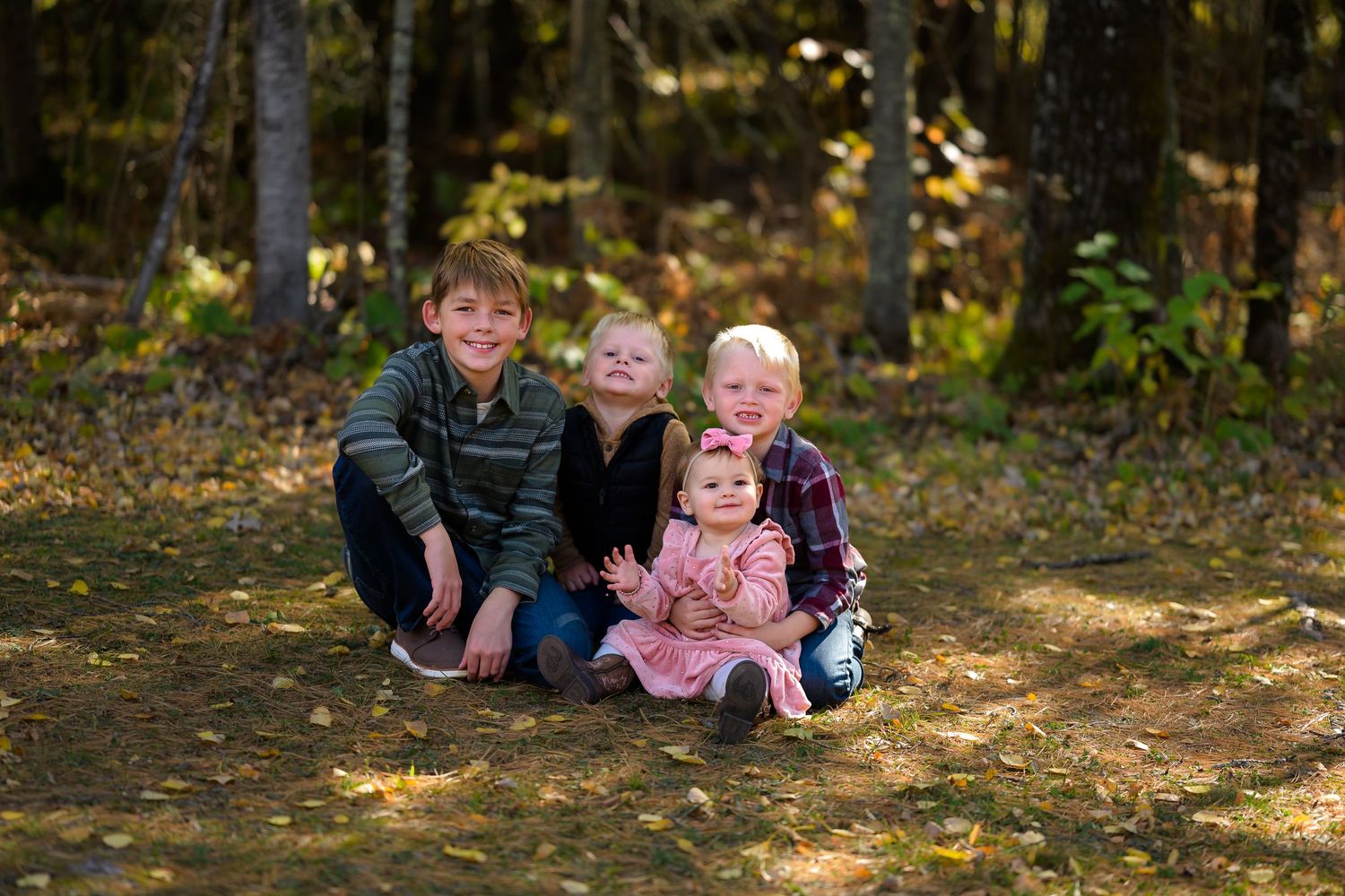 young children posing on grass in fall background