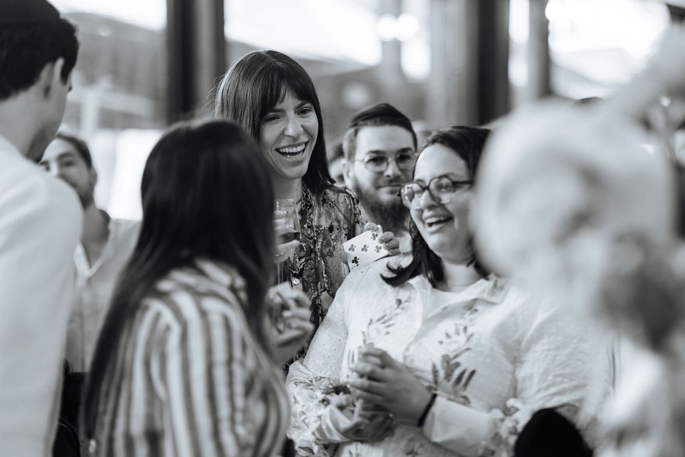 Black and white photo series showing candid moments of joy and laughter at a wedding celebration.