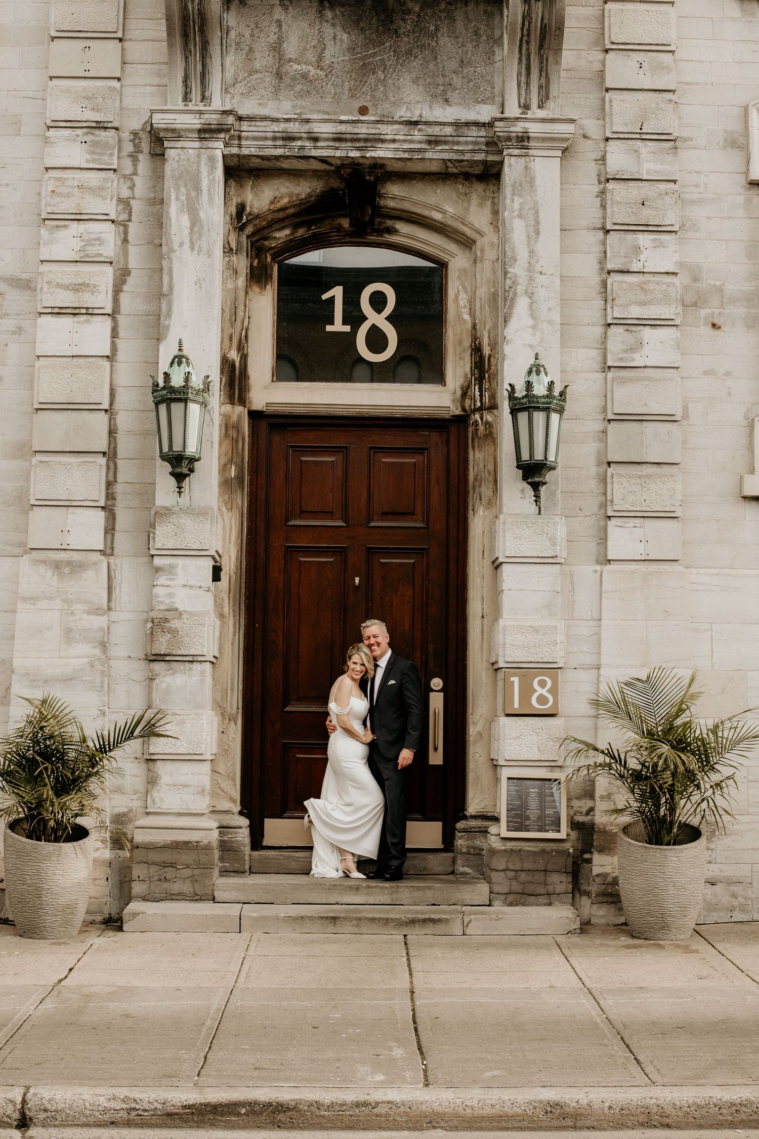 a newly married couple standing outside of a large restaurant door