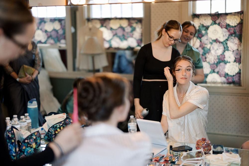 Behind the scenes preparation with makeup artists at work.