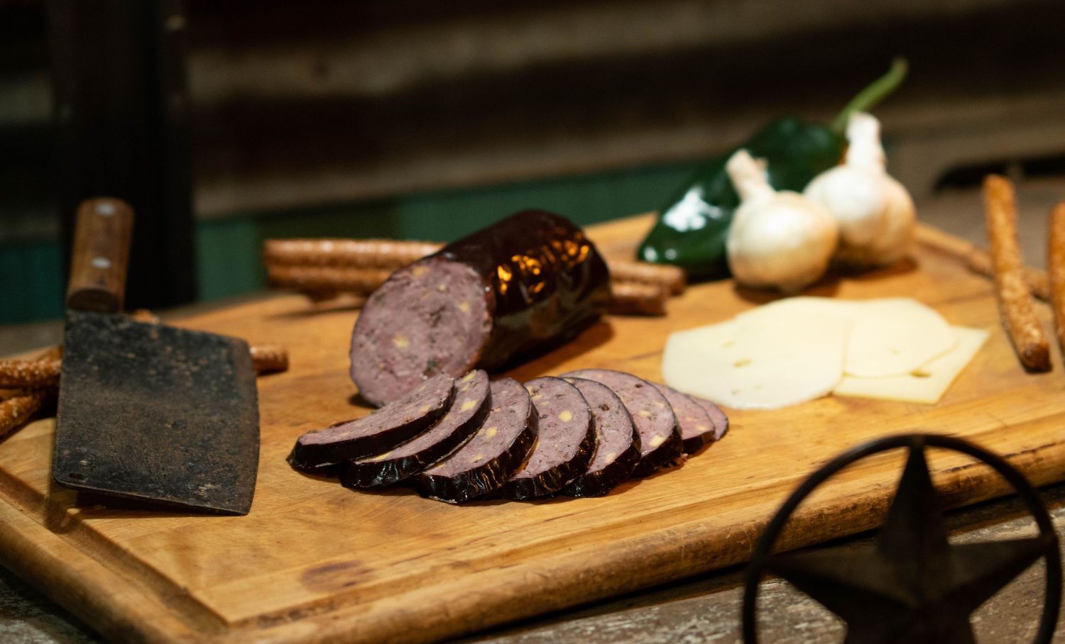 Sliced cured venison arranged on a wooden serving board with garnishes.