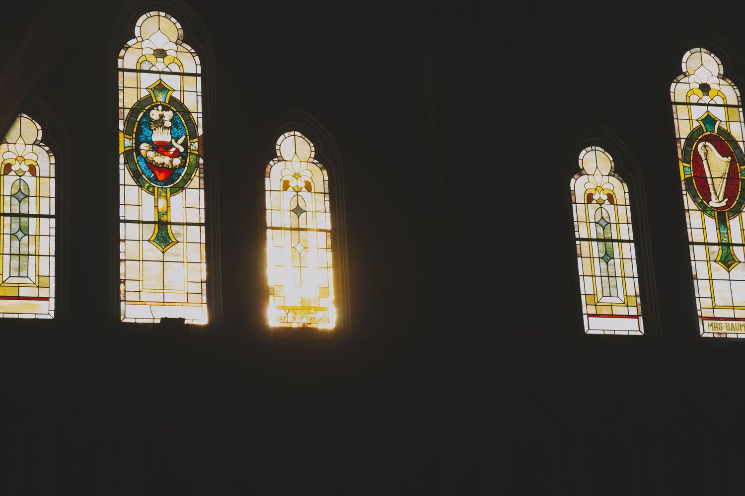 a picture of light streaming through the stained glass windows at st andrew's cathedral in victoria british columbia.