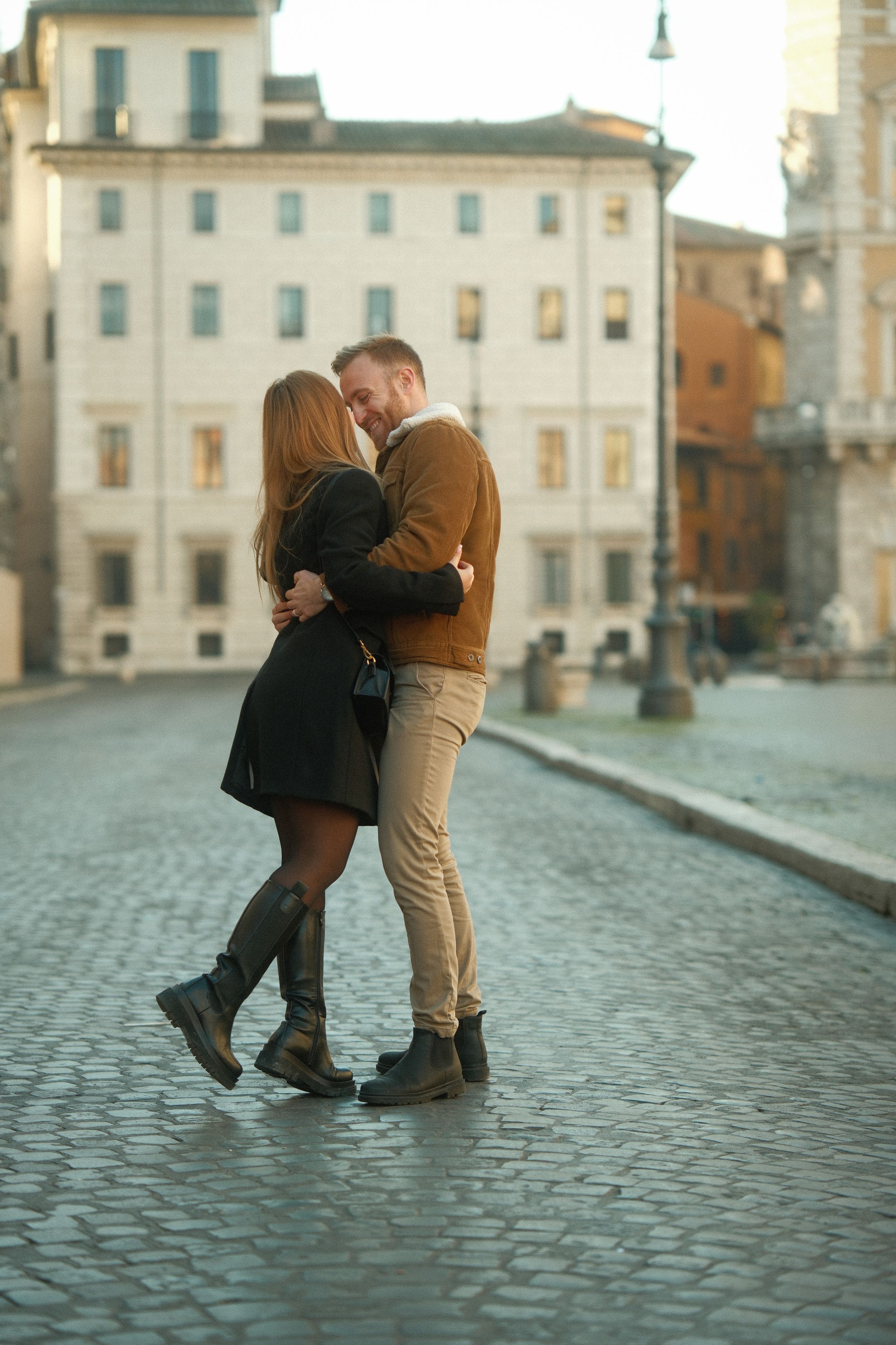A couple embracing on cobblestone streets of Rome.