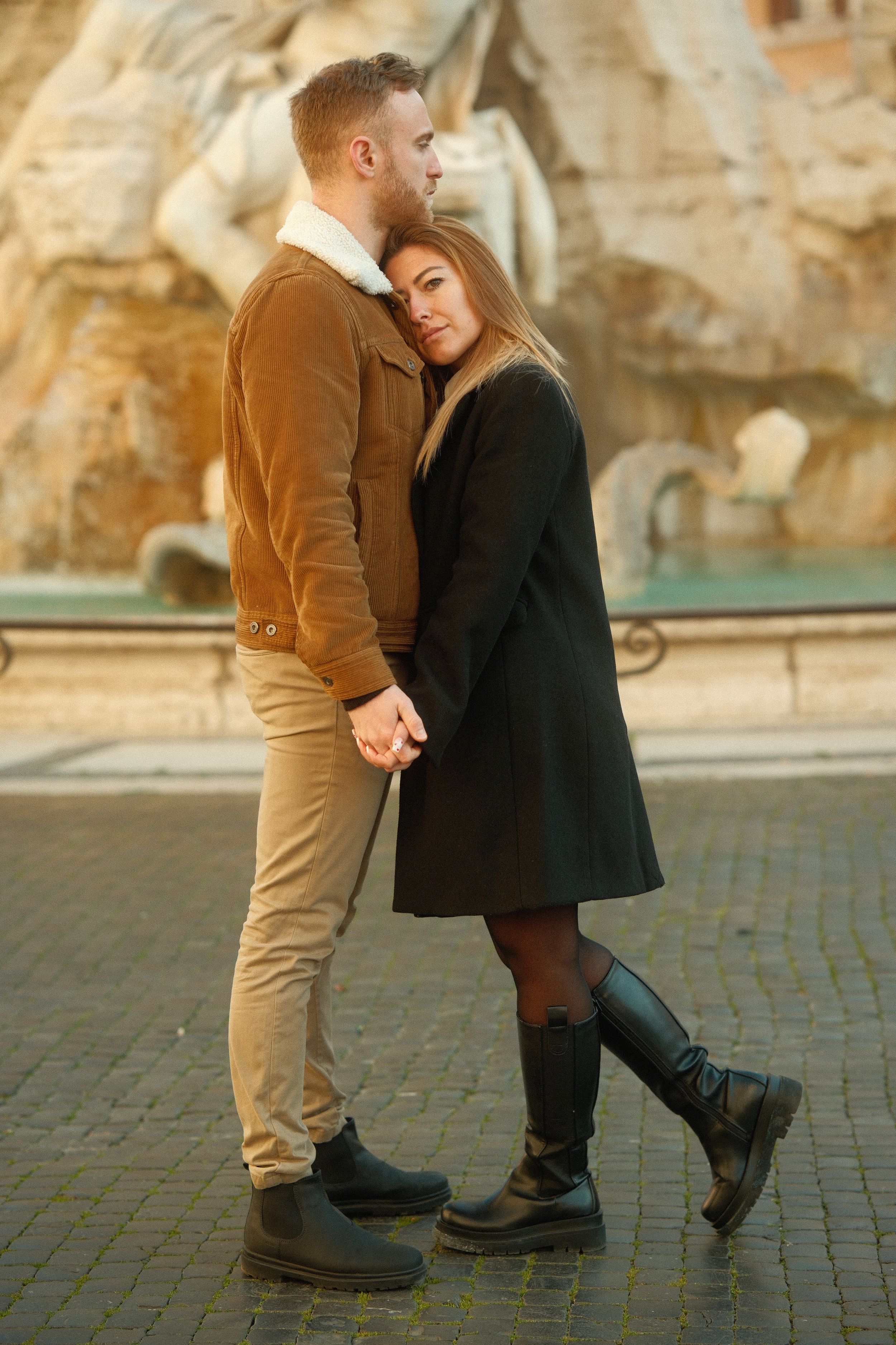 A loving embrace by a historic Roman fountain at golden hour.