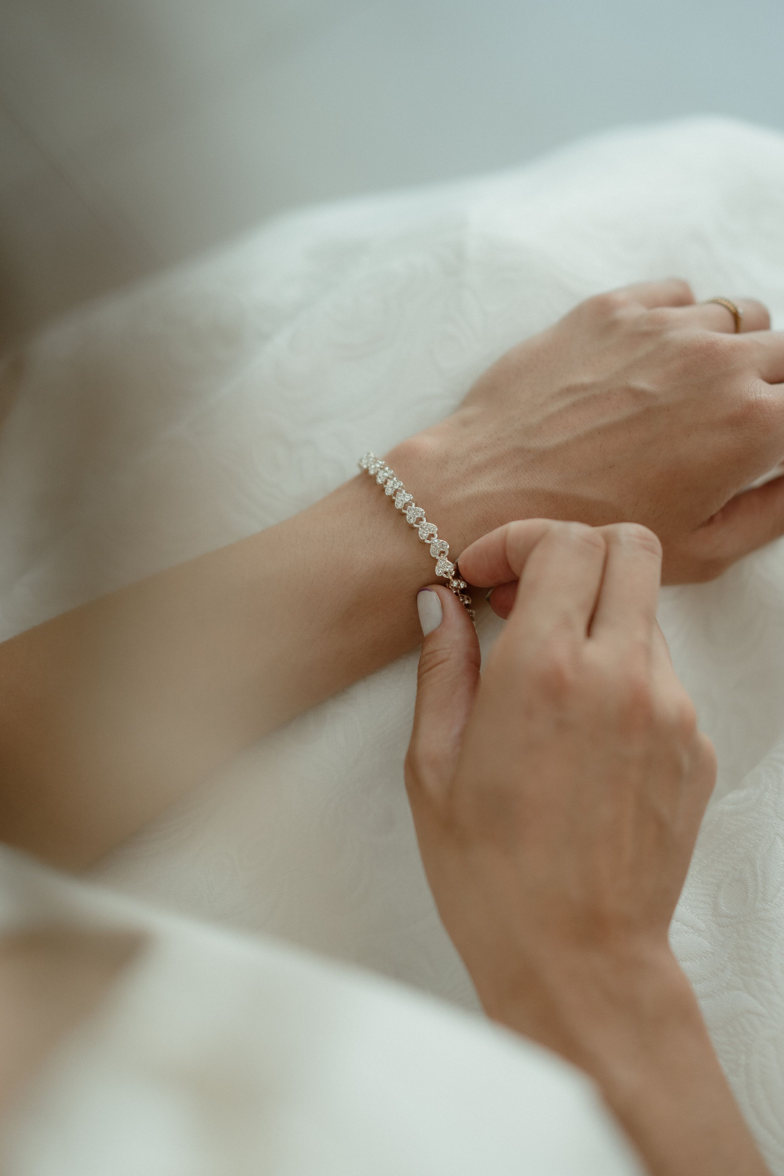 Close-up shots of delicate hands wearing an elegant wedding ring and bracelet.