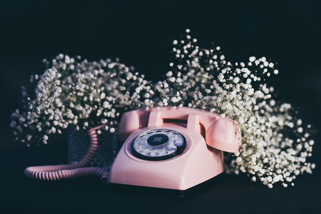 Pink Audio Guest Book Phone with white flowers on a dark background