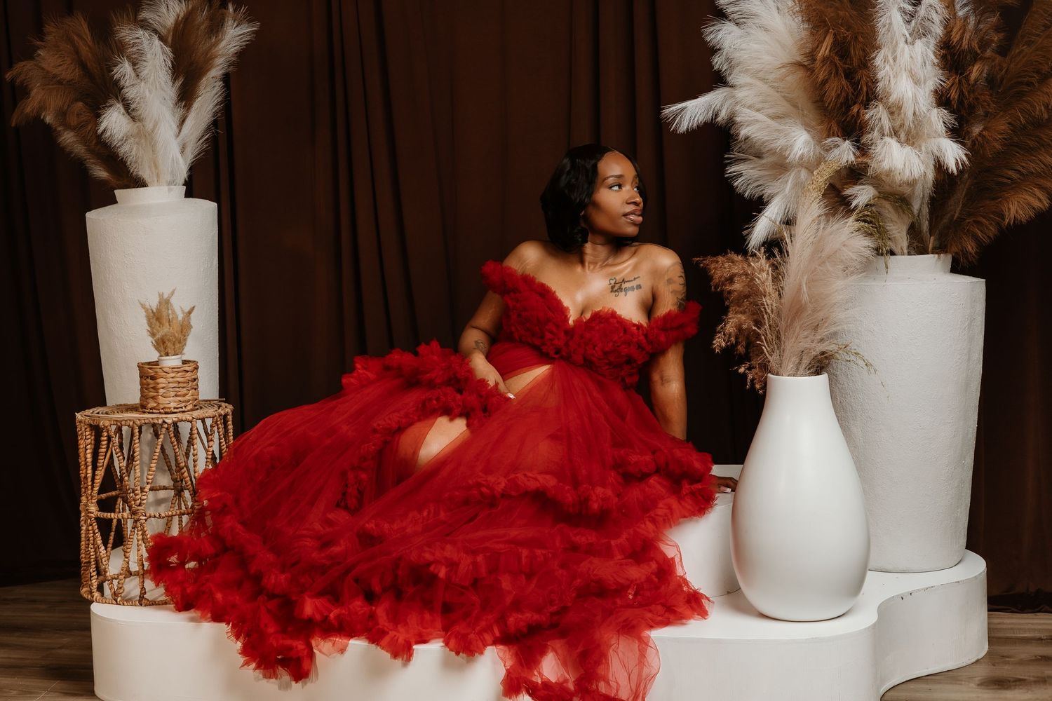 Glamorous maternity photo featuring bright pink tulle gown and golden crown.