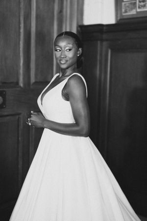 An elegant black and white photo of a bride in a flowing white wedding gown.