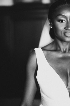 A dramatic black and white close-up bridal portrait showing elegant makeup and white dress.