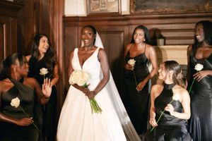 Wedding party in elegant black dresses sharing a joyful moment together.