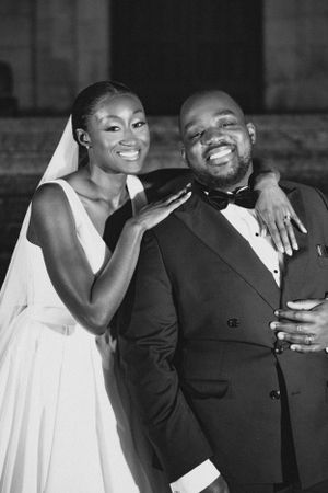 Joyful black and white portrait of newlyweds sharing intimate moment outdoors.
