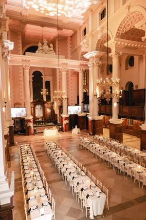 Grand church interior with pink walls and columns set up for an elegant wedding reception.
