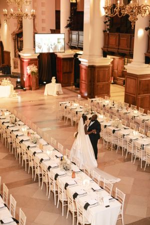 Aerial view of elegant wedding reception setup with long tables and dancing couple.