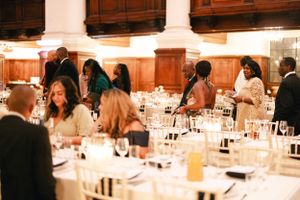 Wedding reception guests seated at decorated tables in an elegant venue with columns.