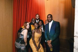 Group of formally dressed guests pose together at an elegant party.