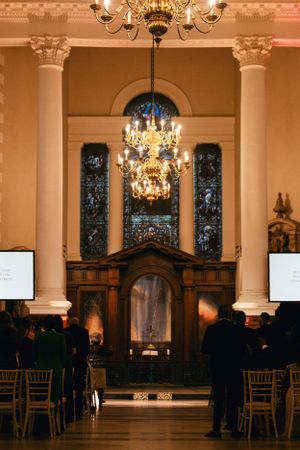 An elegant church interior with ornate chandeliers and stained glass windows.
