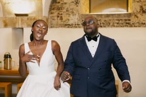 A couple celebrates during their wedding reception with joyful expressions.