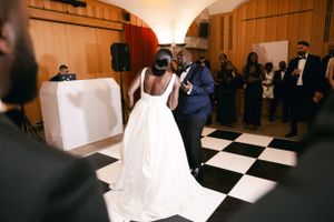 Dancing on a black and white checkered dance floor at an elegant wedding reception.