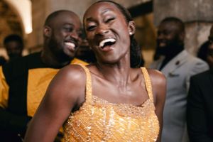 Wedding celebration with guests dancing and laughing in formal attire.