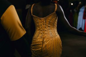 Close-up of a sparkly gold formal dress with intricate beading and design details.