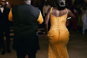 A golden sequined dress shimmers as guests mingle at an elegant evening event.