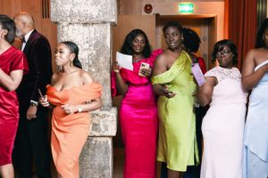 Wedding guests in colorful formal dresses gathered at elegant venue.