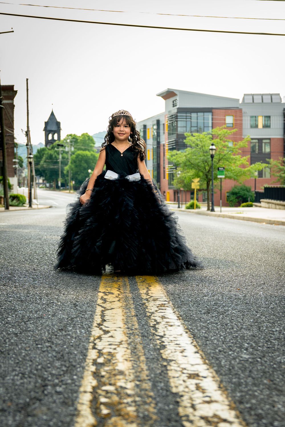Stunning black ball gown photographed in the middle of a city street with yellow lines.