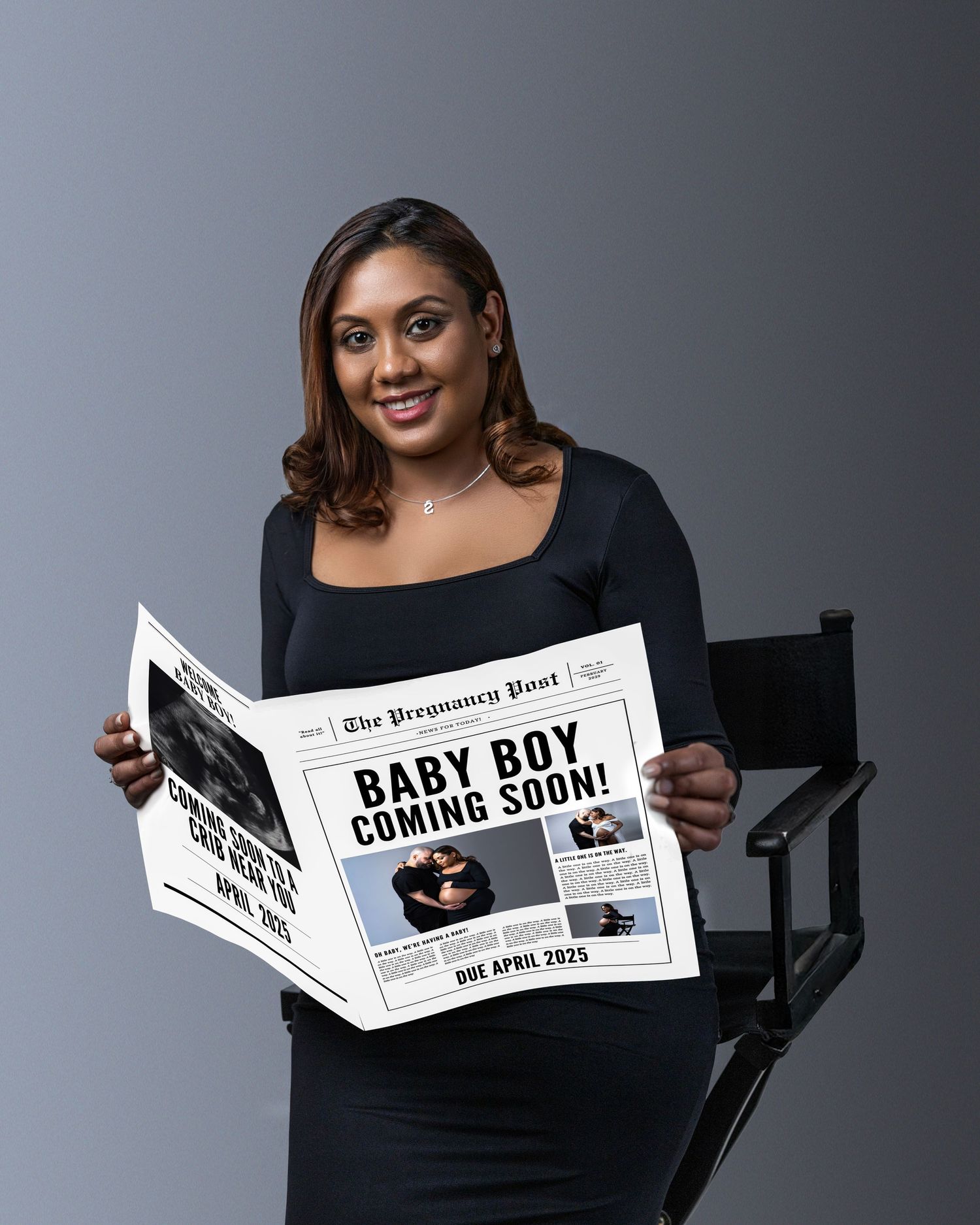 Woman in black top holds newspaper with headline 'BABY BOY COMING SOON!' for pregnancy announcement photo shoot.