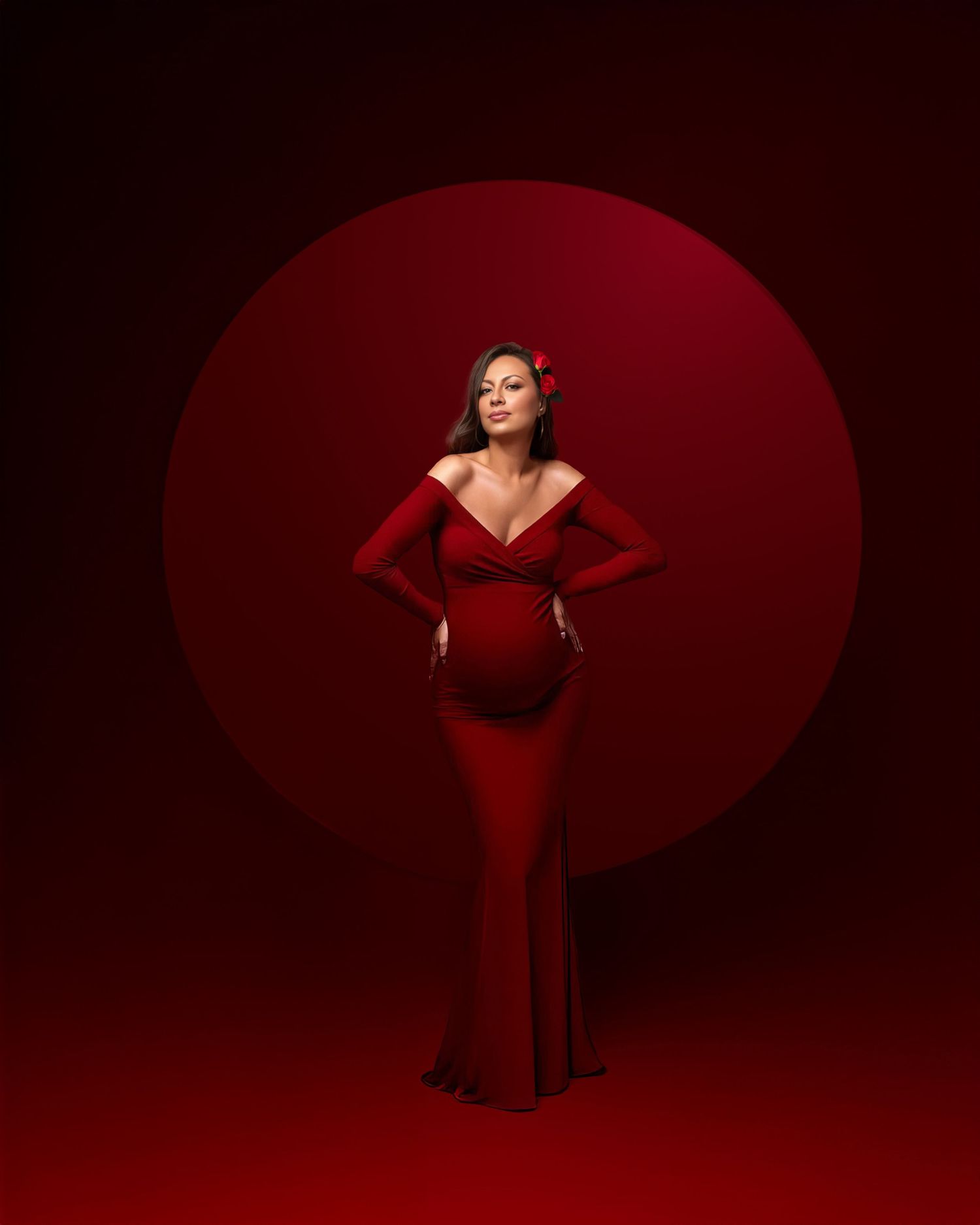 A woman in a form-fitting red evening gown poses dramatically against a deep red circular backdrop.