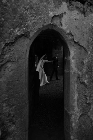 Mysterious black and white photos through dark stone archways in an ancient structure.
