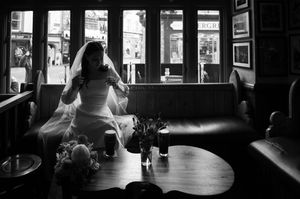 Dark silhouettes in a window-lit interior create a dramatic wedding scene.