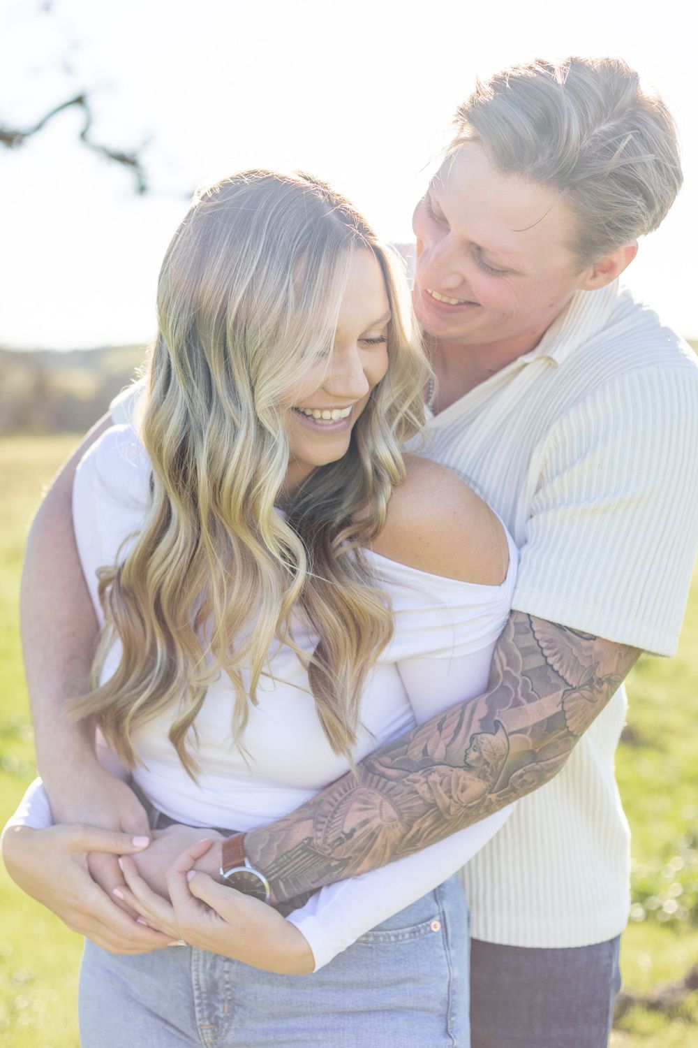Couple's portrait, featuring the two of them smiling and looking at each other, with a clean background and natural light.