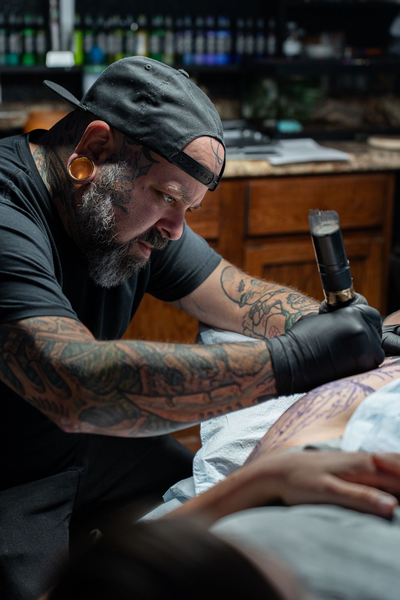 Tattoo shop featuring a skilled artist creating a unique tattoo design on a client's arm, highlighting the artistry