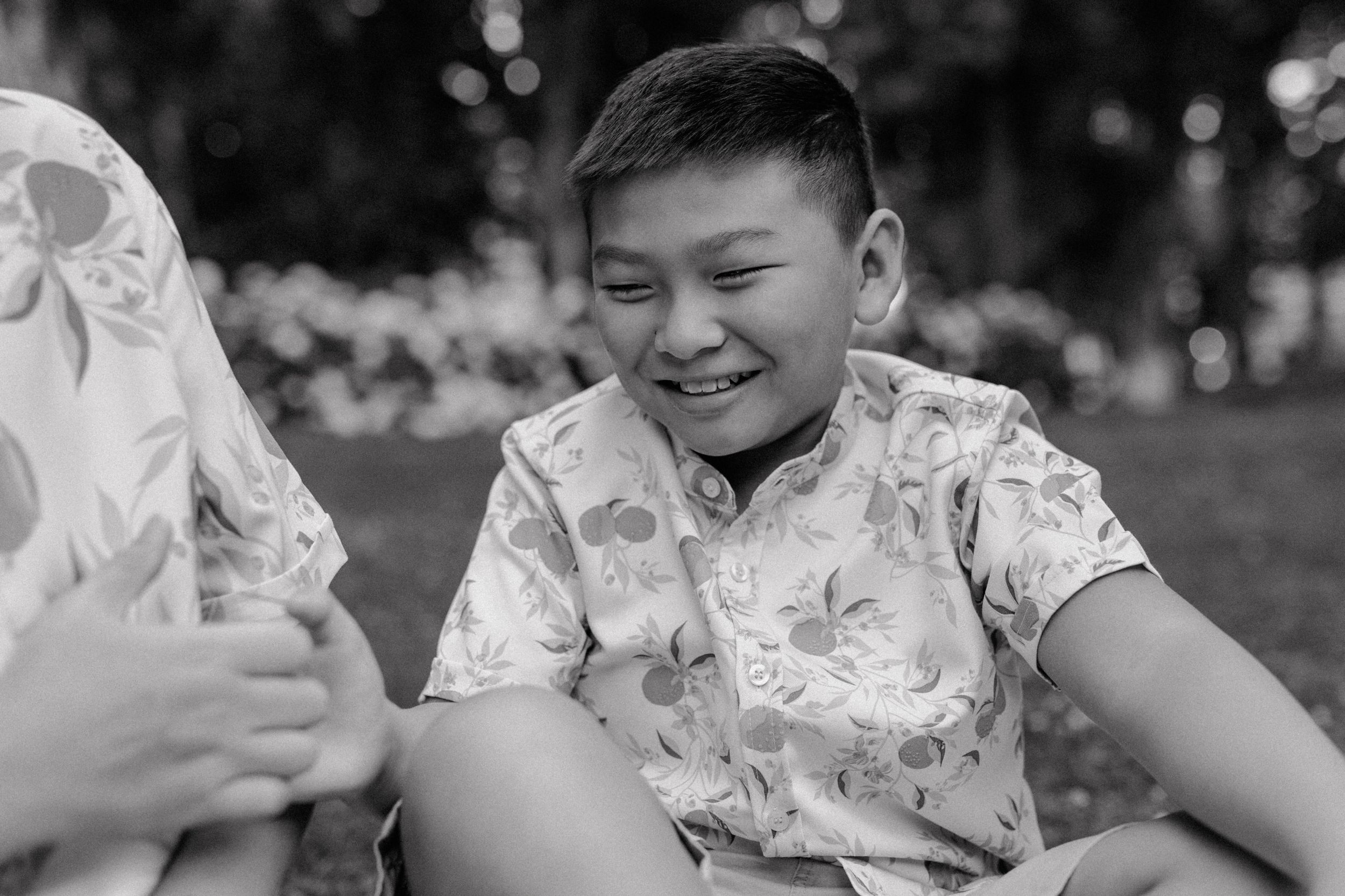 Close-up of the 10-year-old laughing as their parents smile next to him during a playful moment in the city.