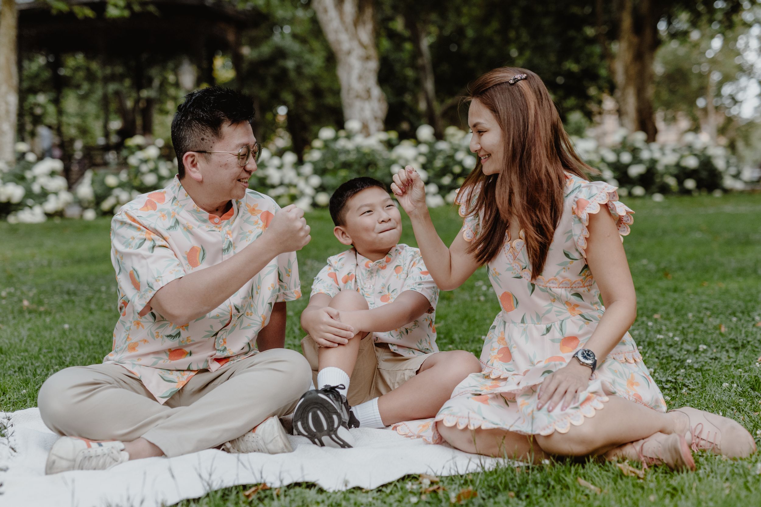 Parents playing with each other while their child giggles in the middle, capturing a sweet family moment.